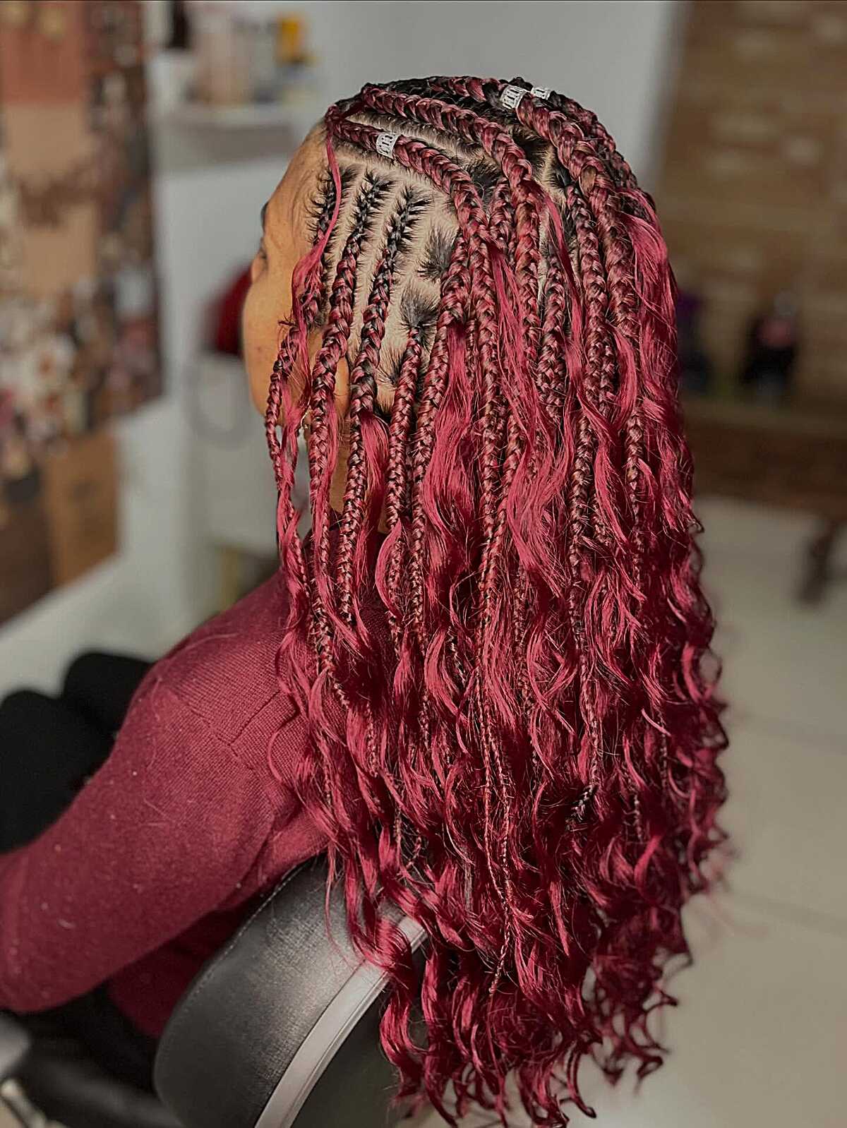 Burgundy box braids with loose curly ends and pink-red variation