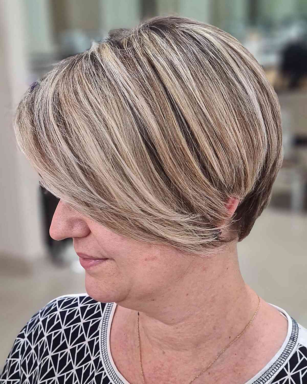 Cheek-length pixie bob with soft side fringe and blonde tones.