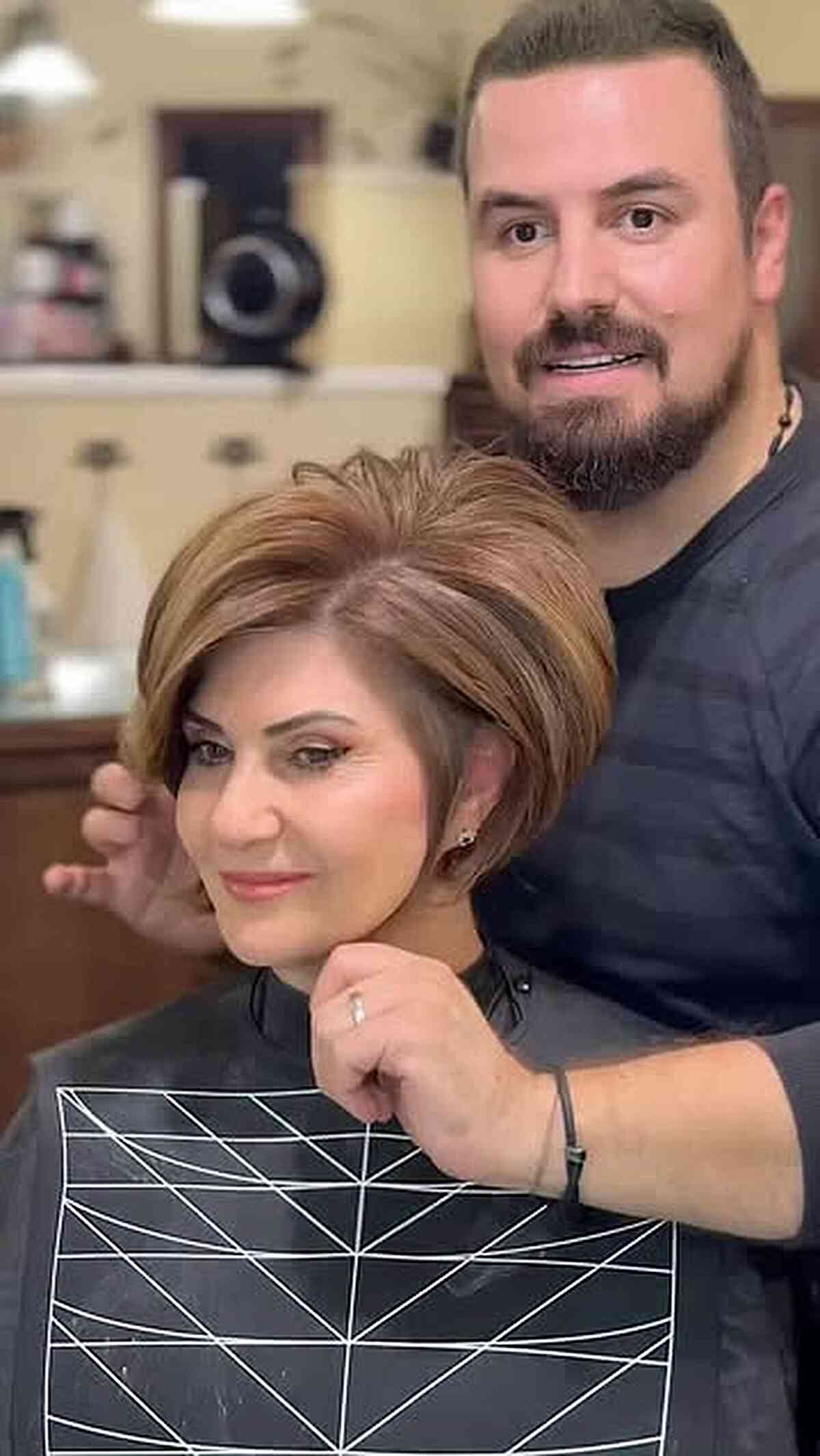 Rounded brunette pixie bob with layered top and side-swept volume.