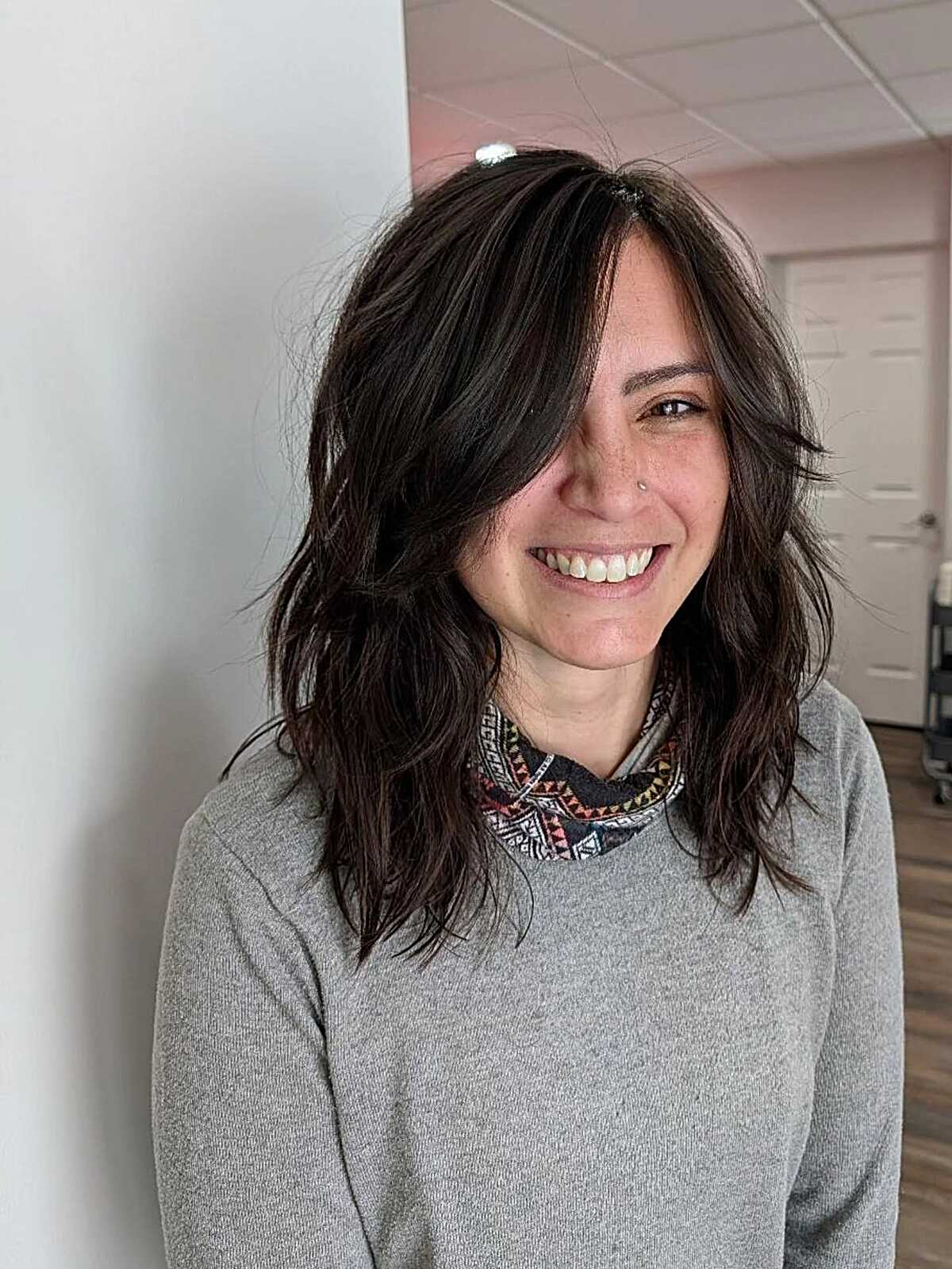 Dark wavy shag with side-swept bangs and layered ends.