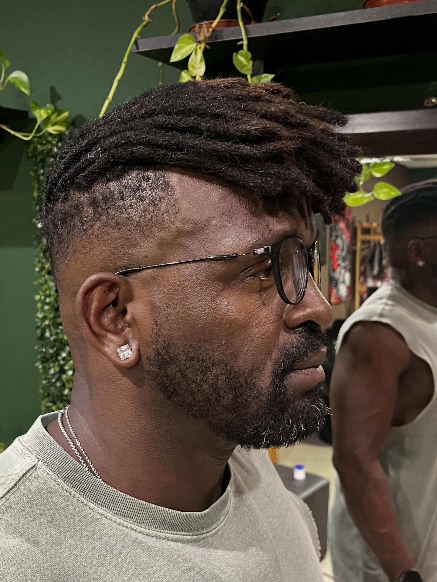 Thick dreadlocks on top with closely faded sides.