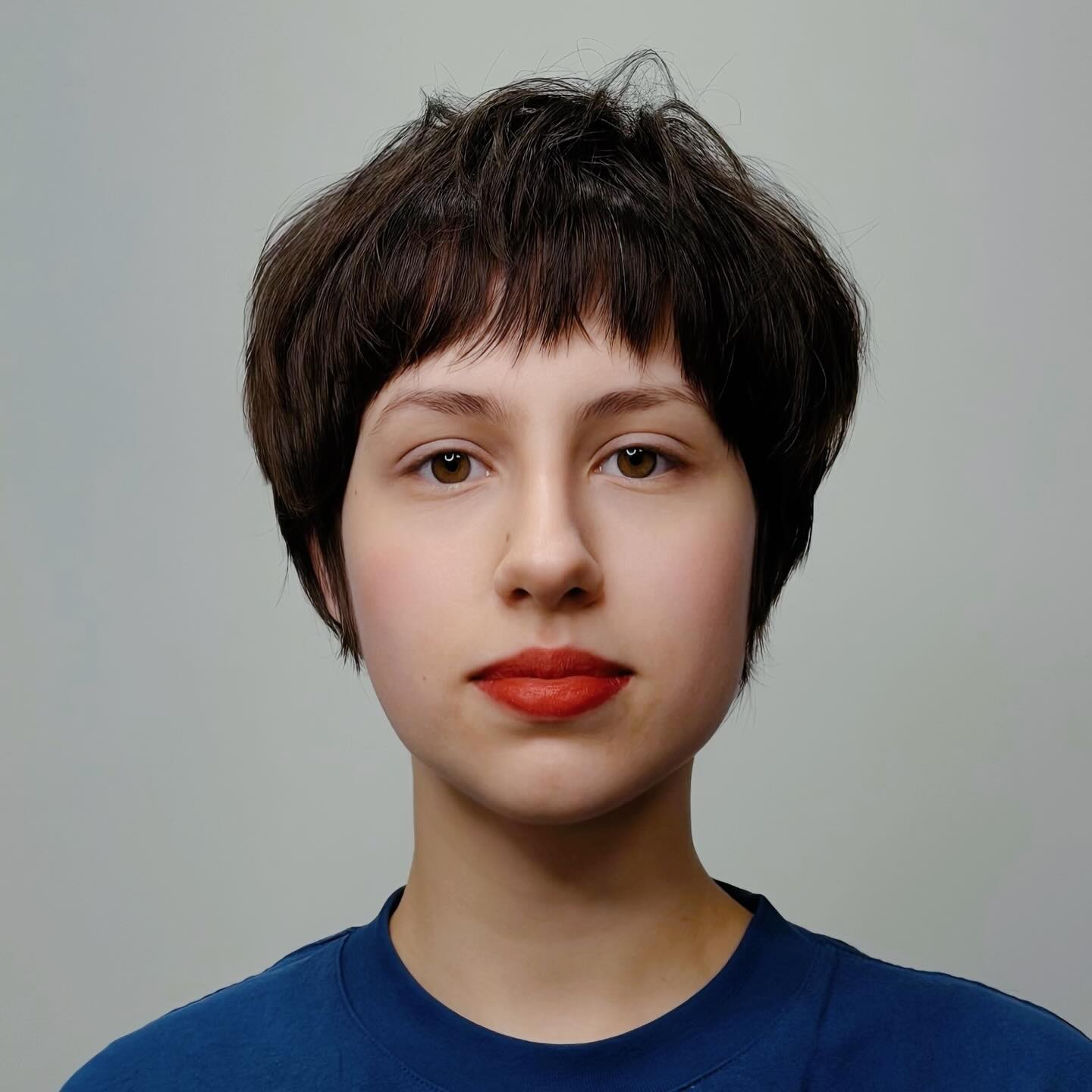 Dark rounded pixie with short fringe and compact sides.