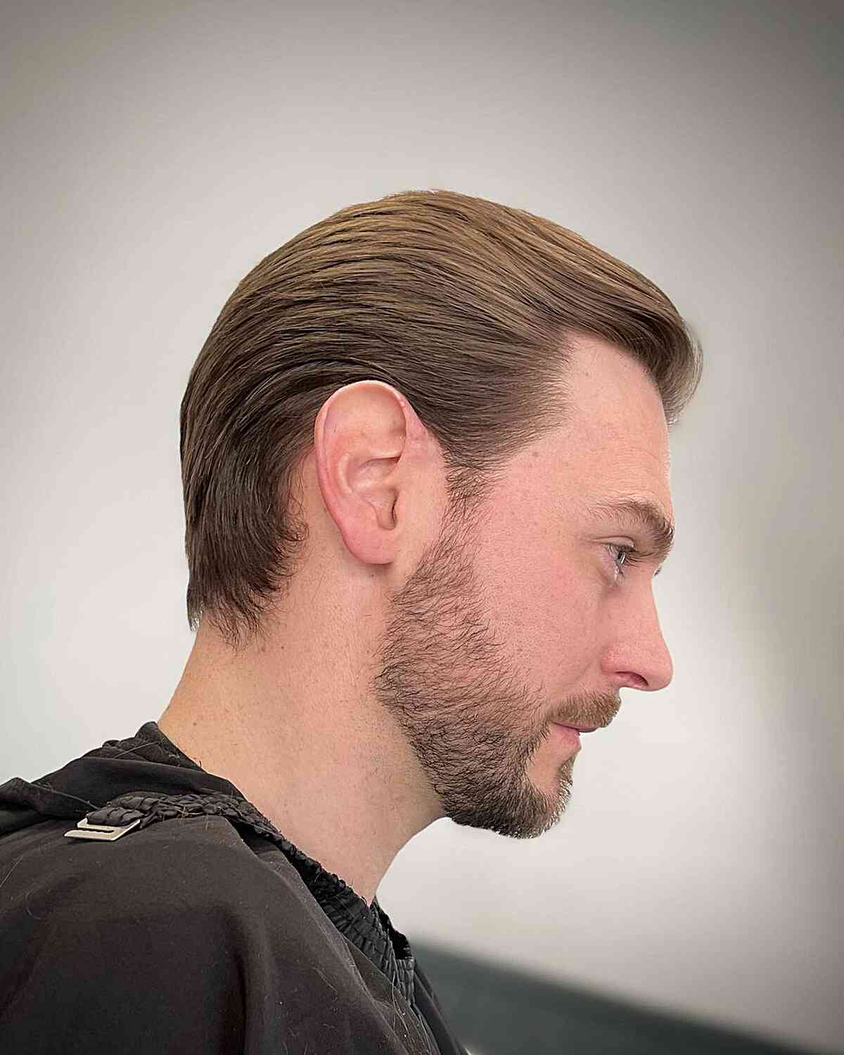 Slicked-back medium brown haircut with taper