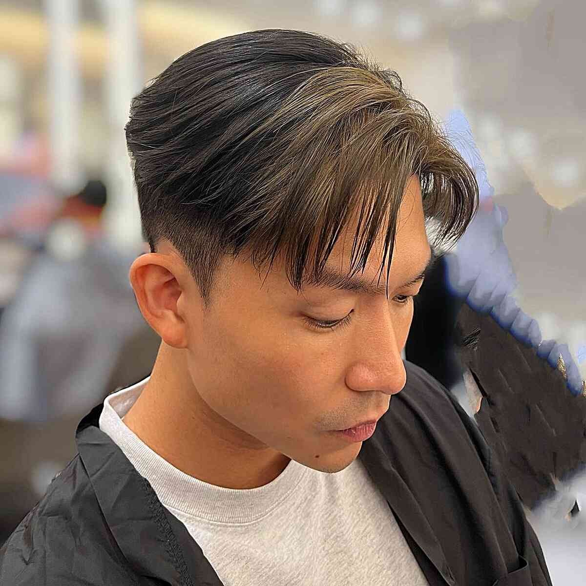 Swept men’s cut with dark base and ash-blonde streaks
