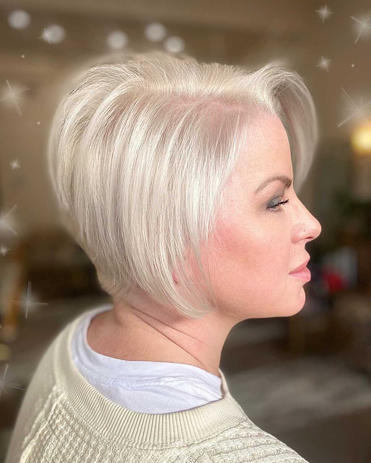 Platinum blonde angled bob with a lifted crown and forward curve.