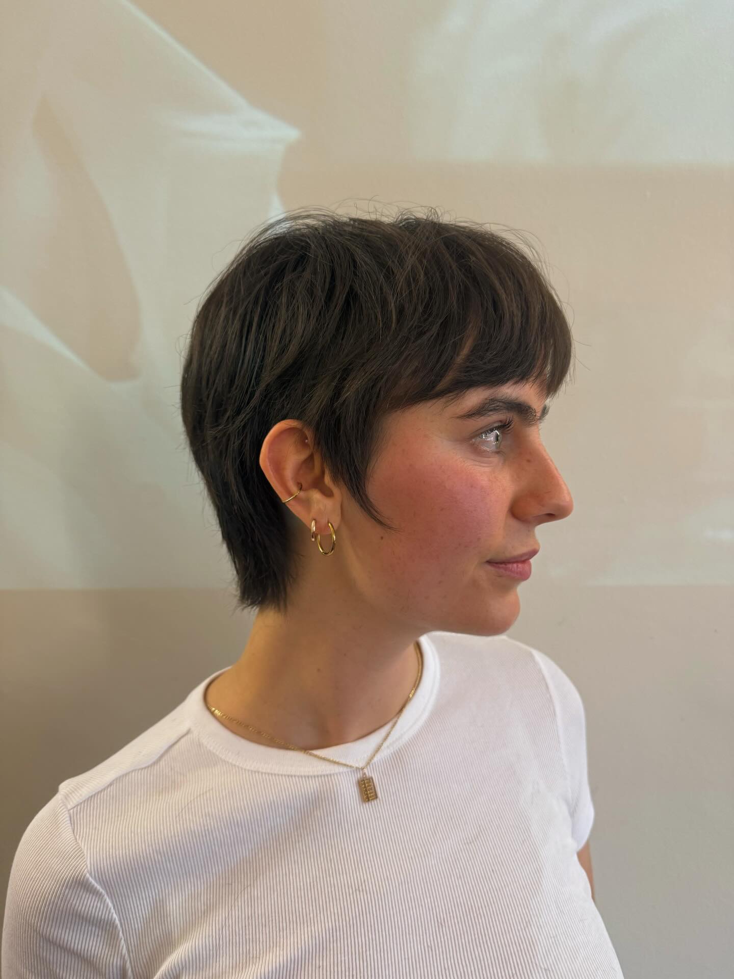 Textured dark pixie with cropped fringe and tapered nape.
