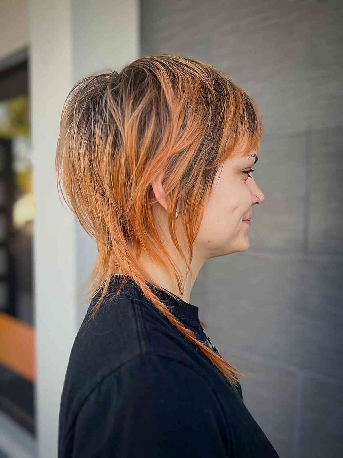 Copper-highlighted shag with short crown layers and longer wispy nape pieces.