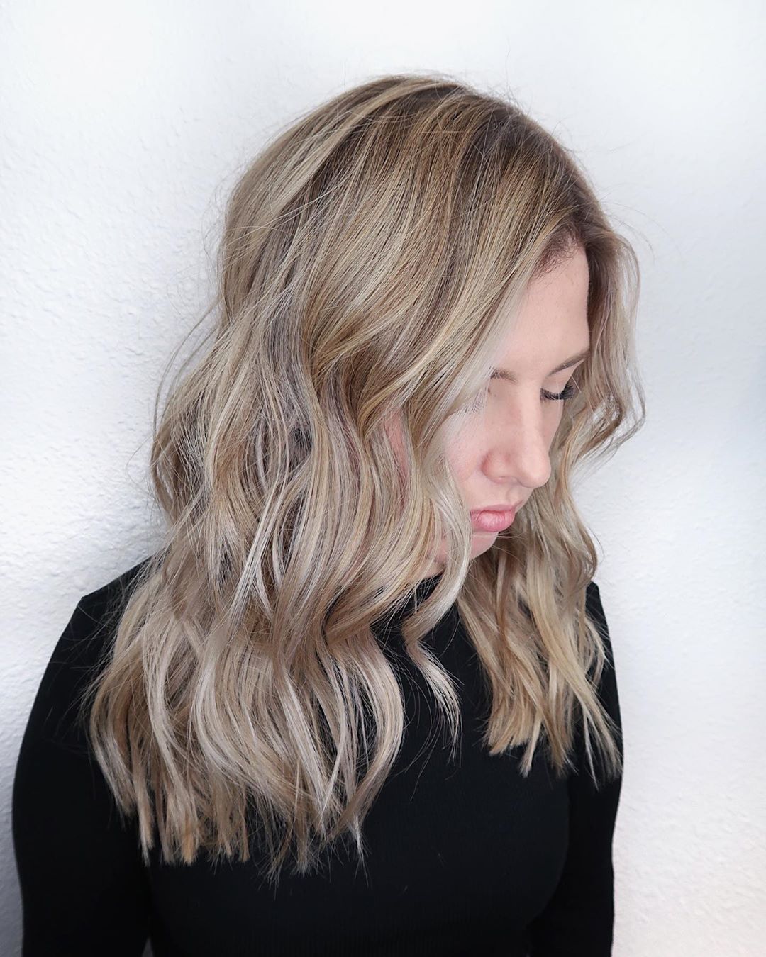 Shoulder-length beige platinum waves with a side part.