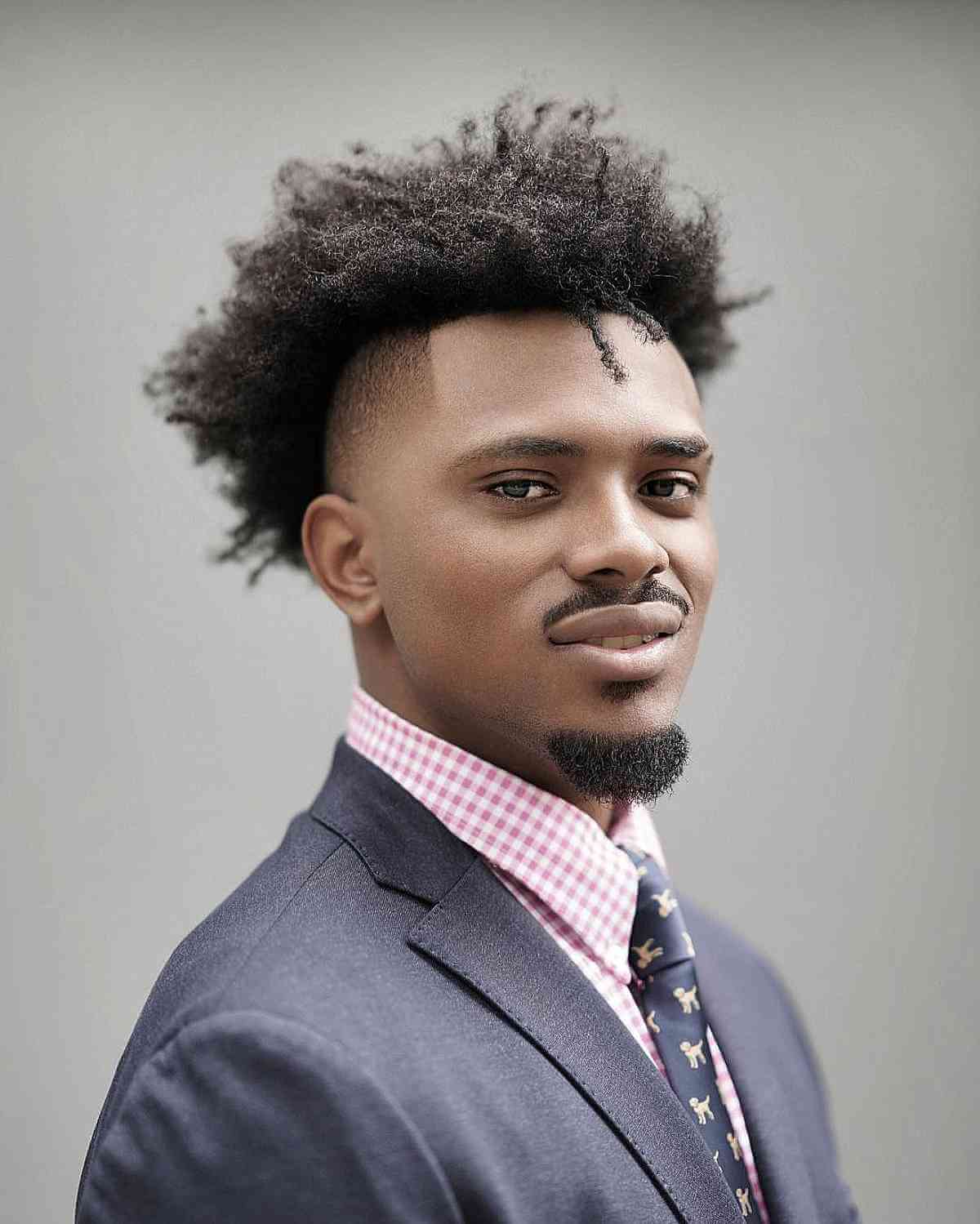Loose curly top with a fade and a squared front hairline.
