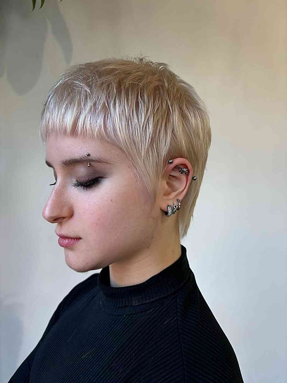 Short platinum pixie with micro fringe and tapered sides.