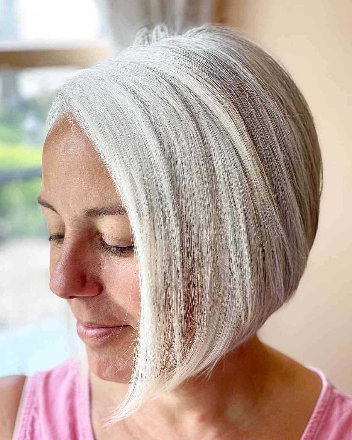 Stacked blonde angled bob with a compact nape and smooth finish.