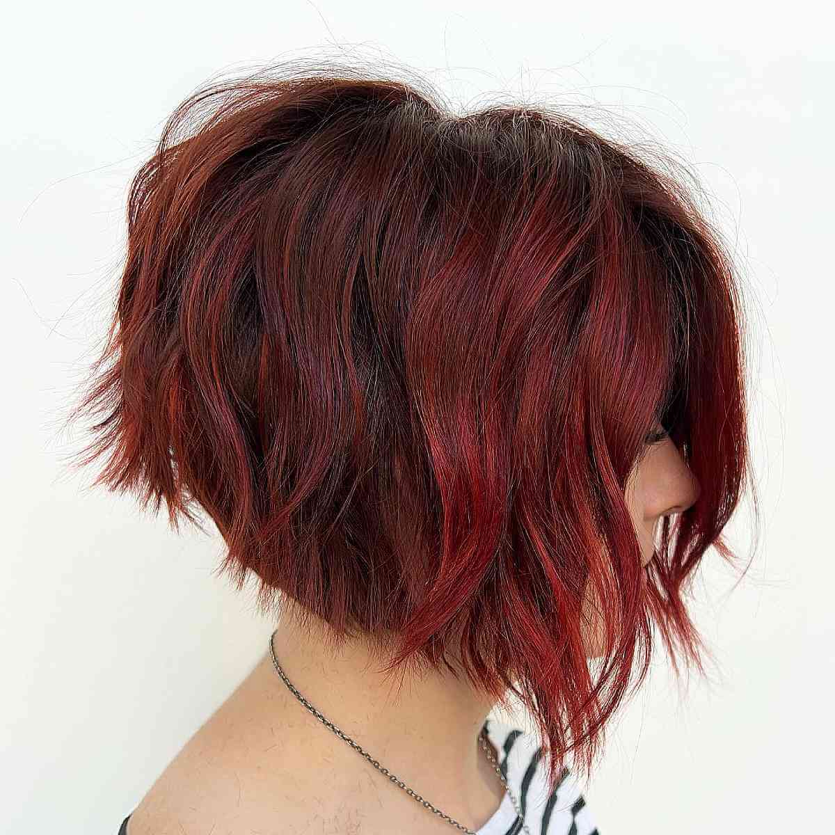 Ruby red angled bob with tousled layers and choppy ends.
