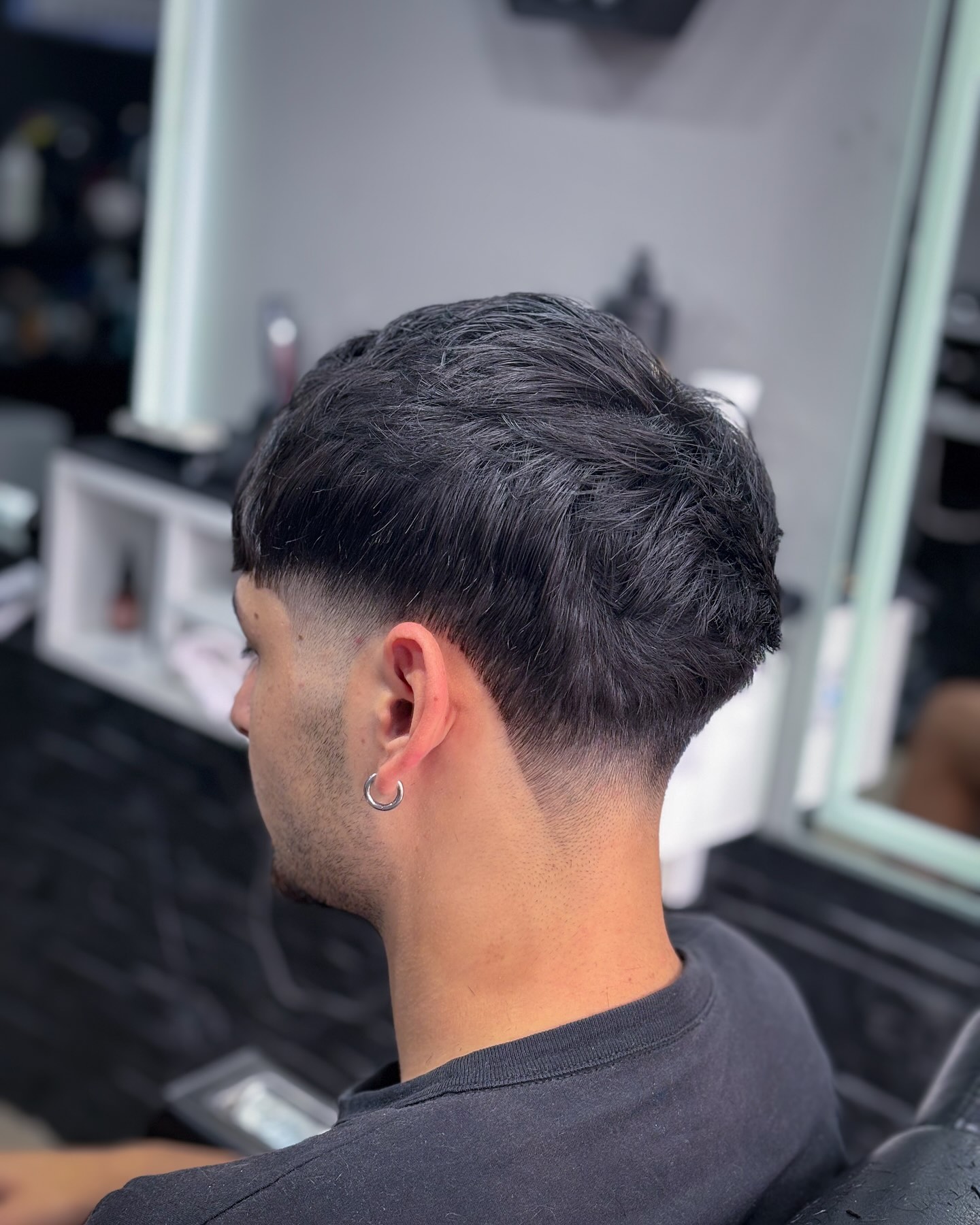 Choppy dark top with tight side fade and rounded back.