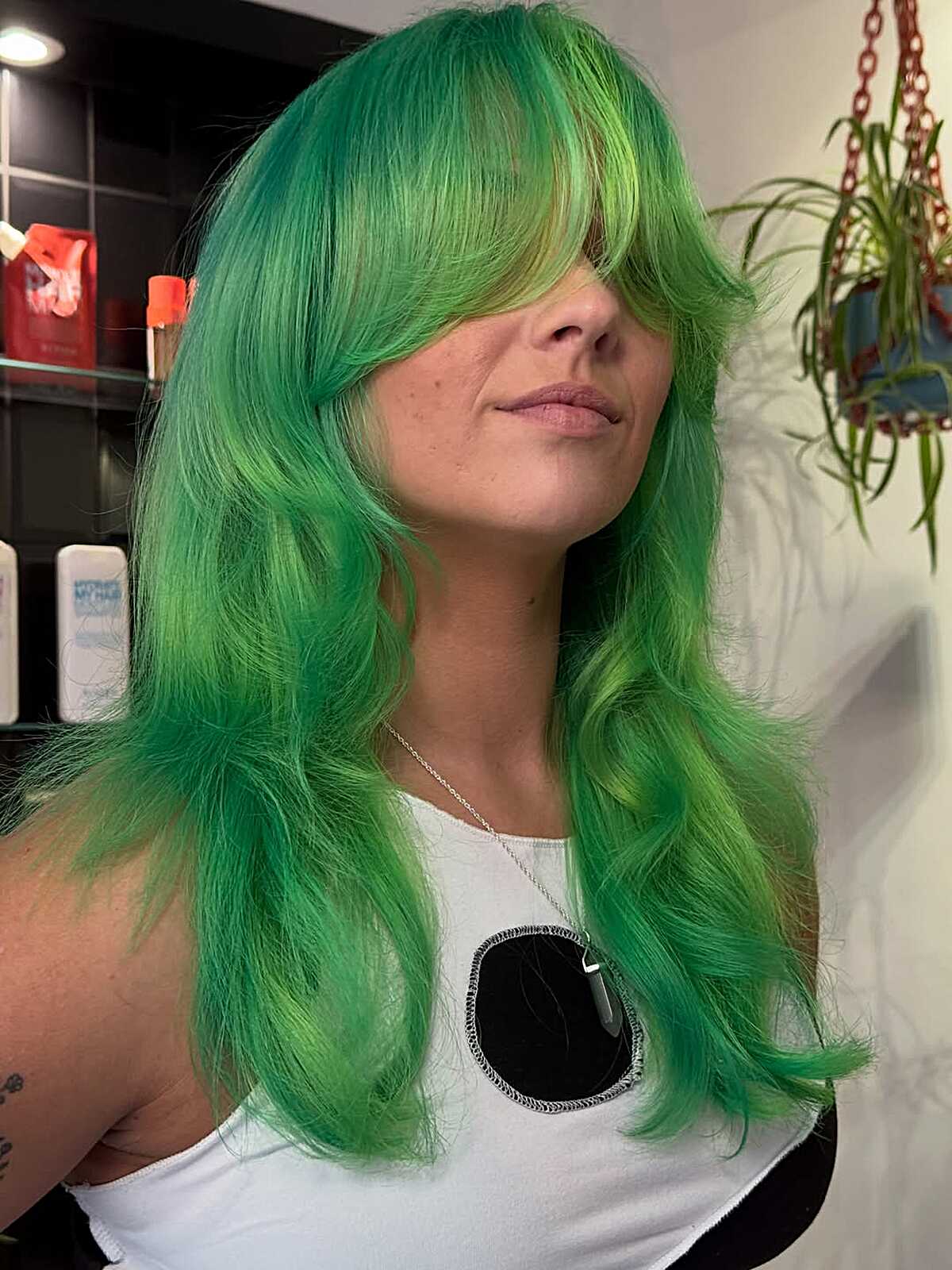 Long neon green hair with full bangs and layered ends.