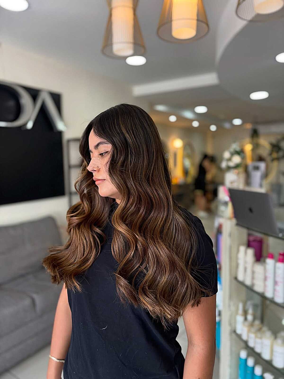 Long brunette waves with caramel balayage and soft movement.