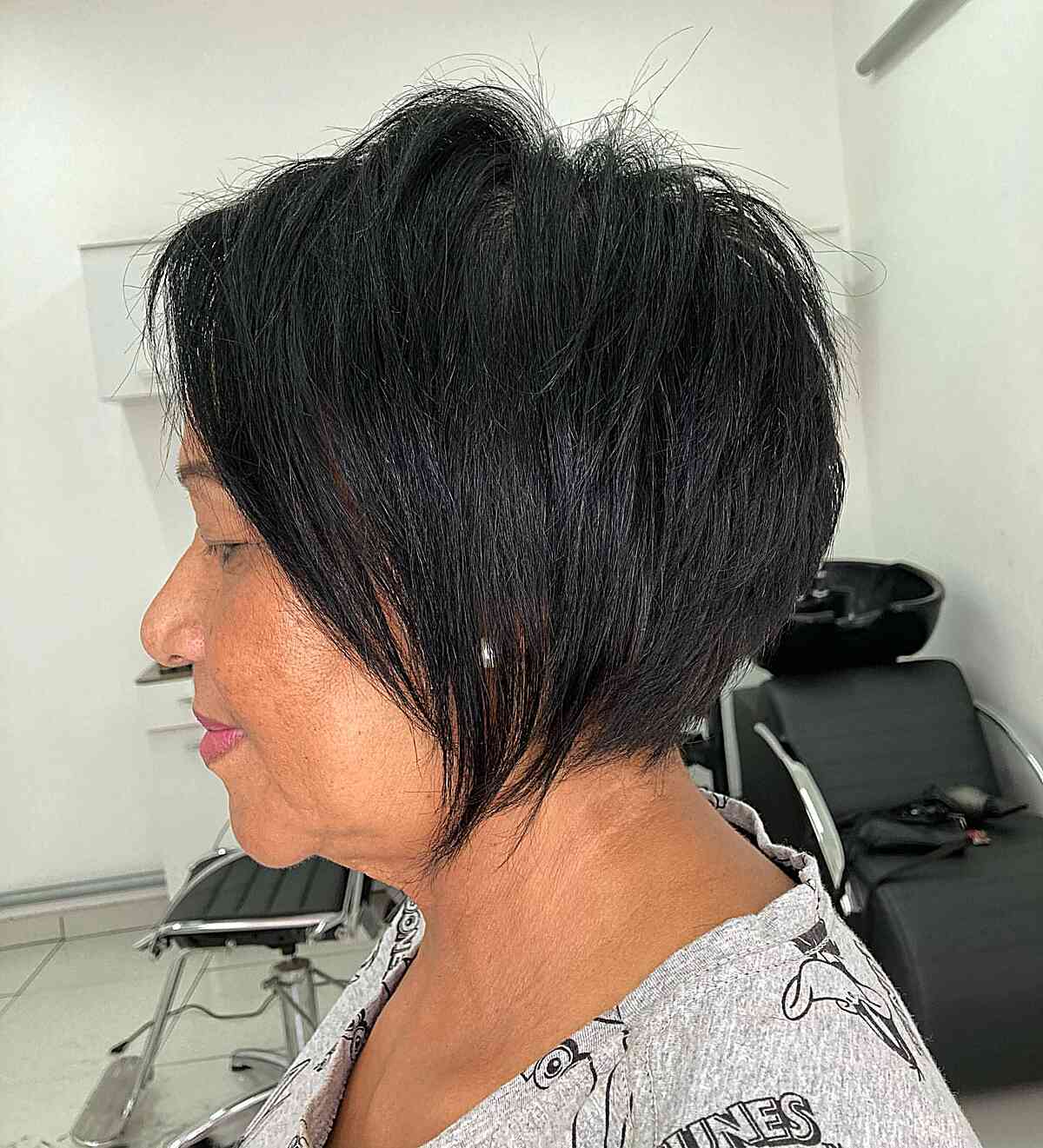 Black tapered pixie bob with choppy layers and textured top.