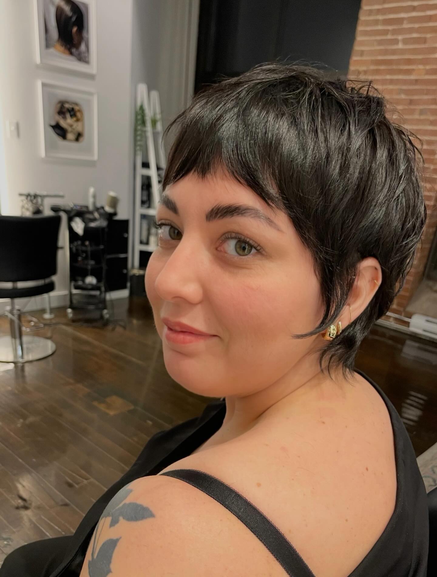Black long pixie with short micro bangs and tapered sides.