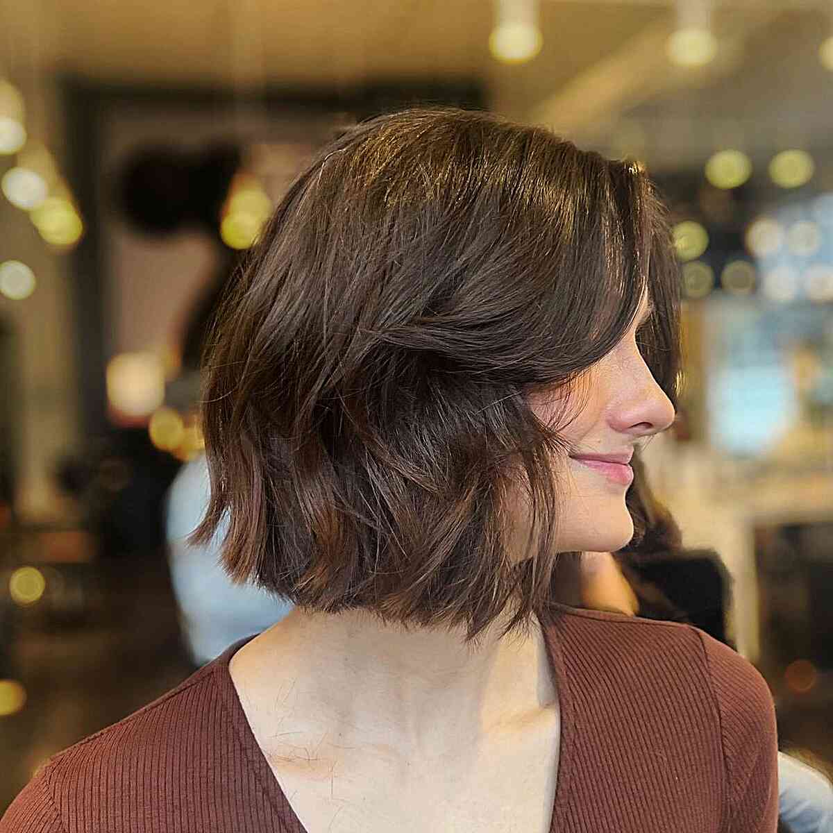 Jaw-length brown bob with curtain bangs and soft layers