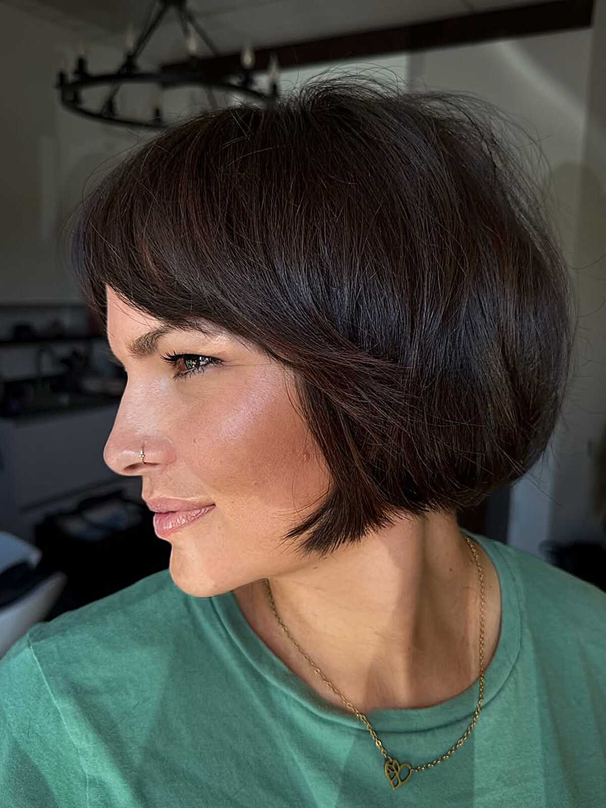 Short dark stacked bob with wispy fringe and tapered side length.