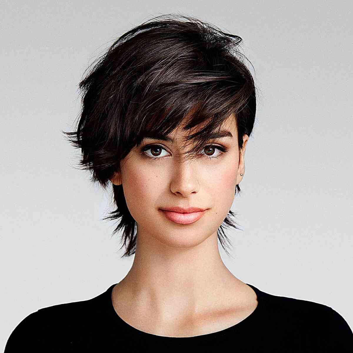 Short dark pixie with side-swept fringe and textured layers