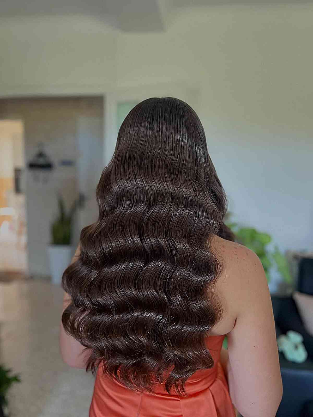 Long dark hair with shiny defined waves from midlengths down.