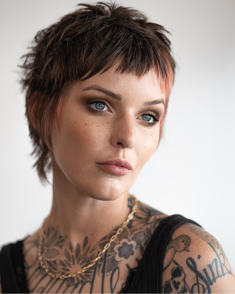 Short choppy pixie with micro fringe and copper accents.