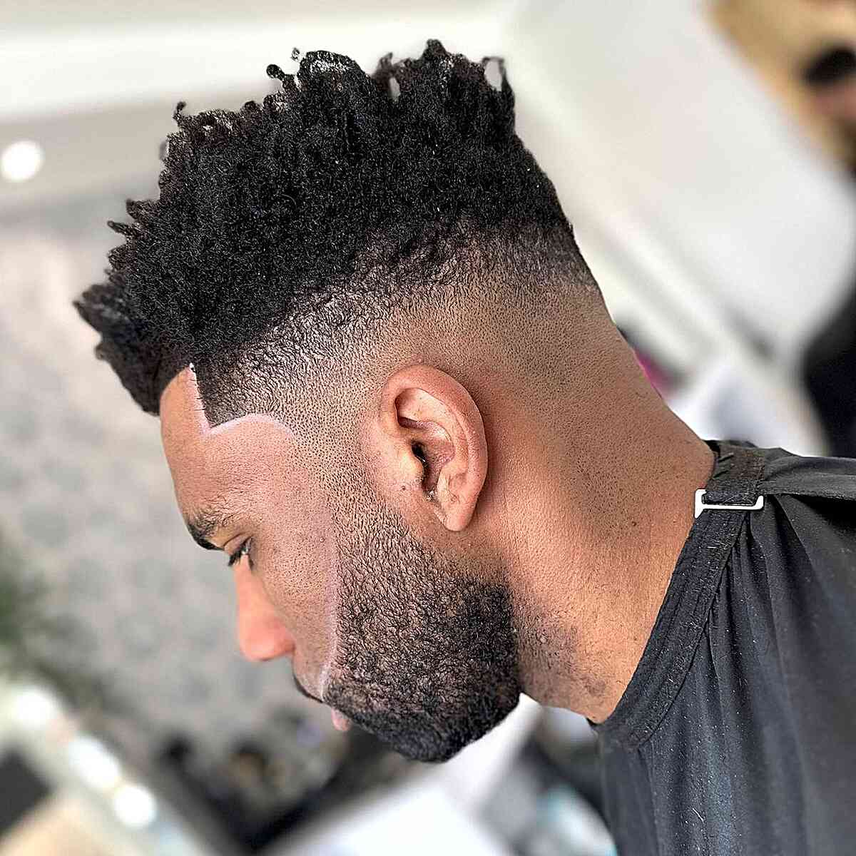 Textured mohawk-style top with skin fade and boxed beard.