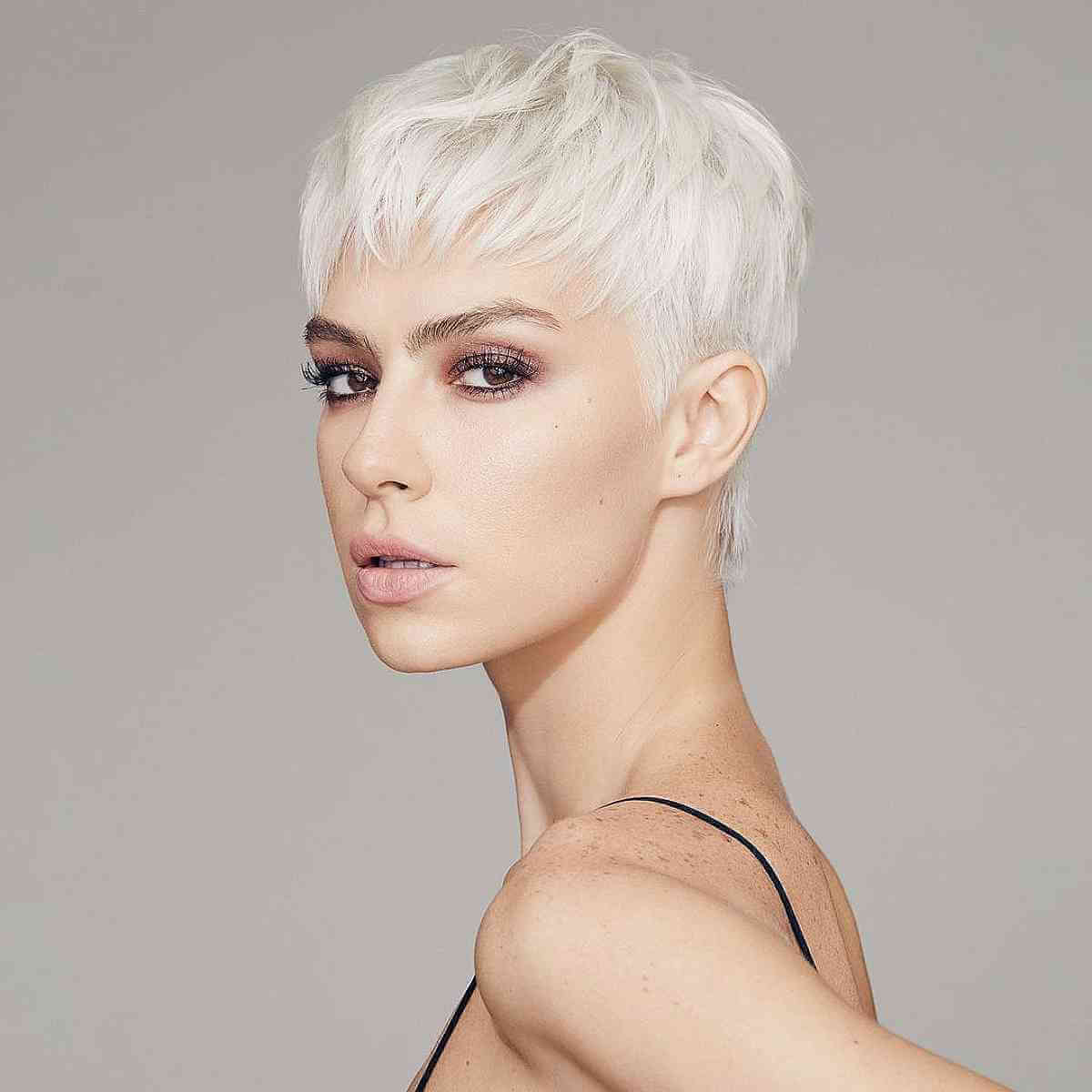 Very short white-platinum pixie with soft top layering.