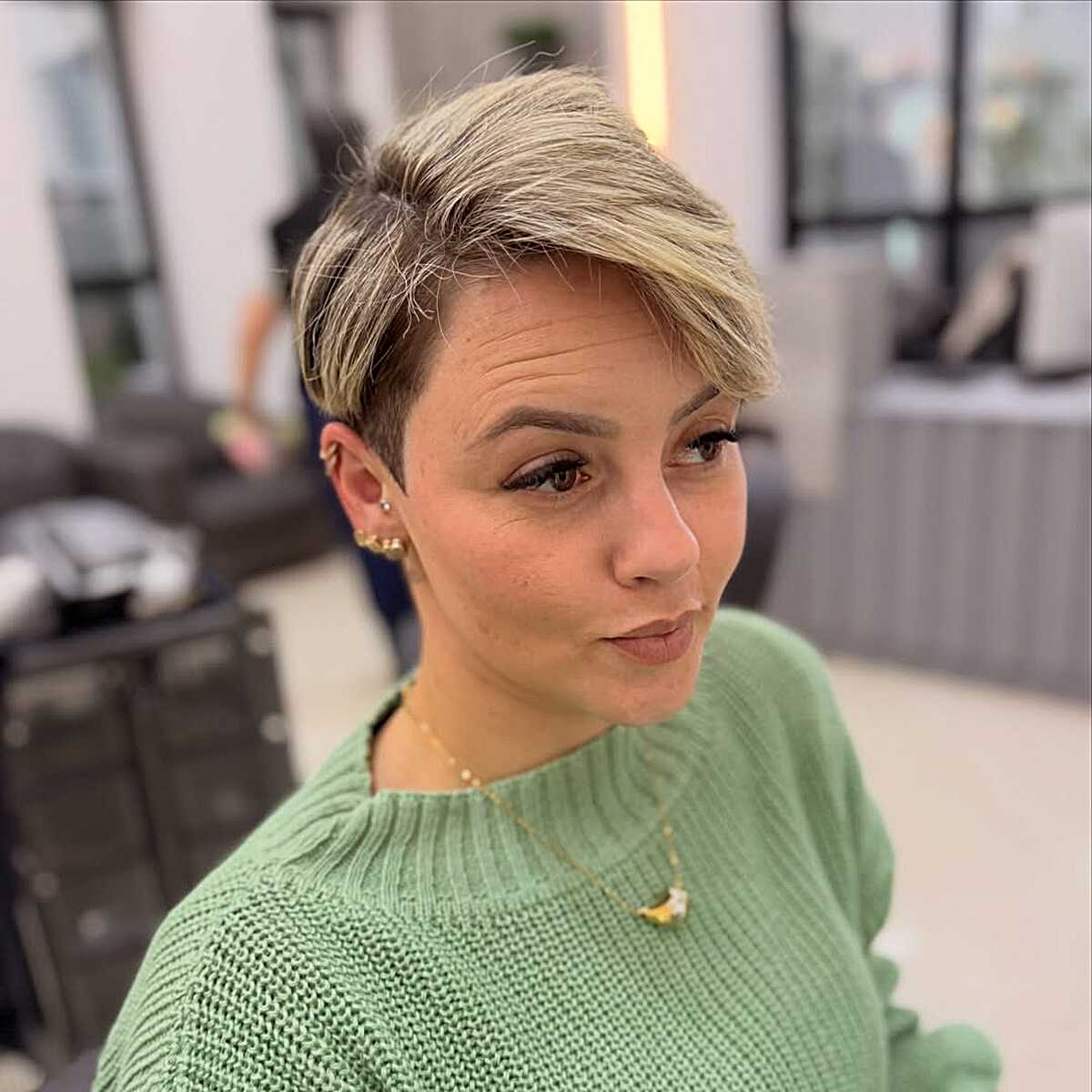 Ash blonde pixie with side-swept top and tapered undercut.