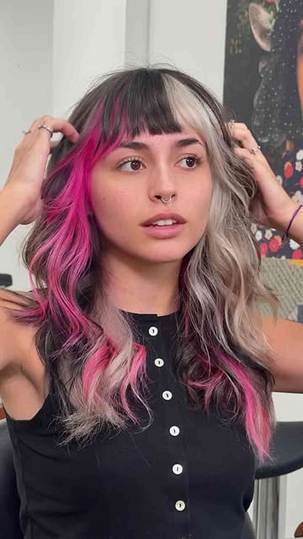 Wavy layered hair with blunt bangs and split black, silver, and pink color panels.