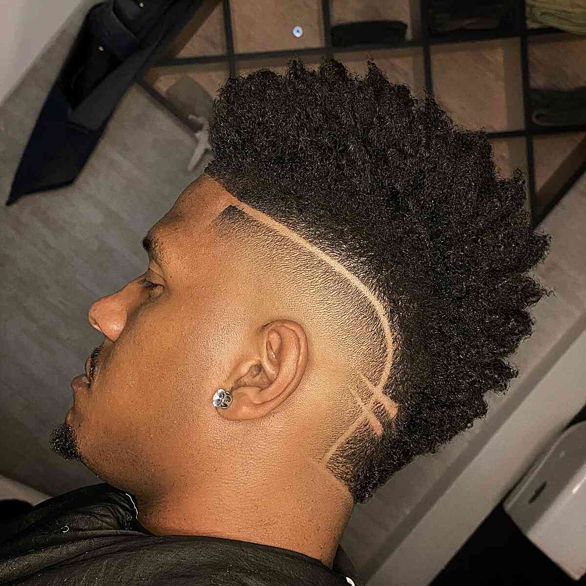 Tall textured top with a high fade and curved side part.