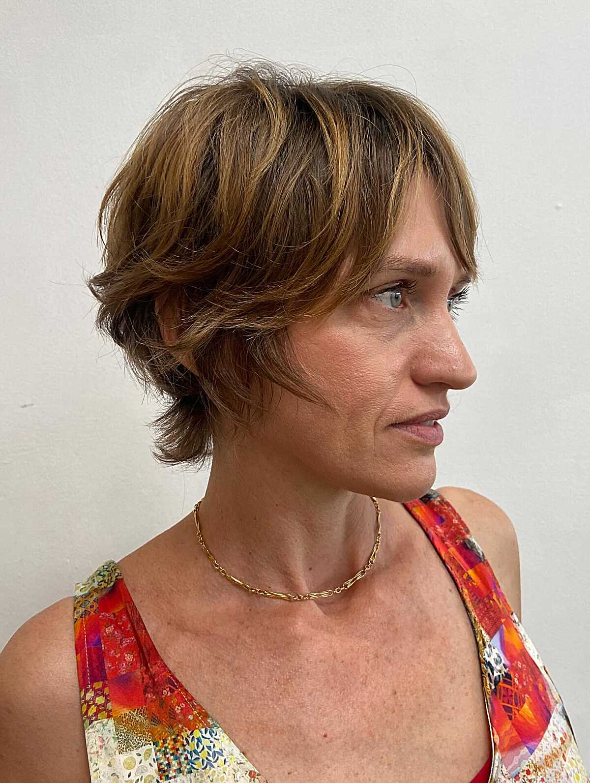 Brunette pixie with flippy nape length and textured top.