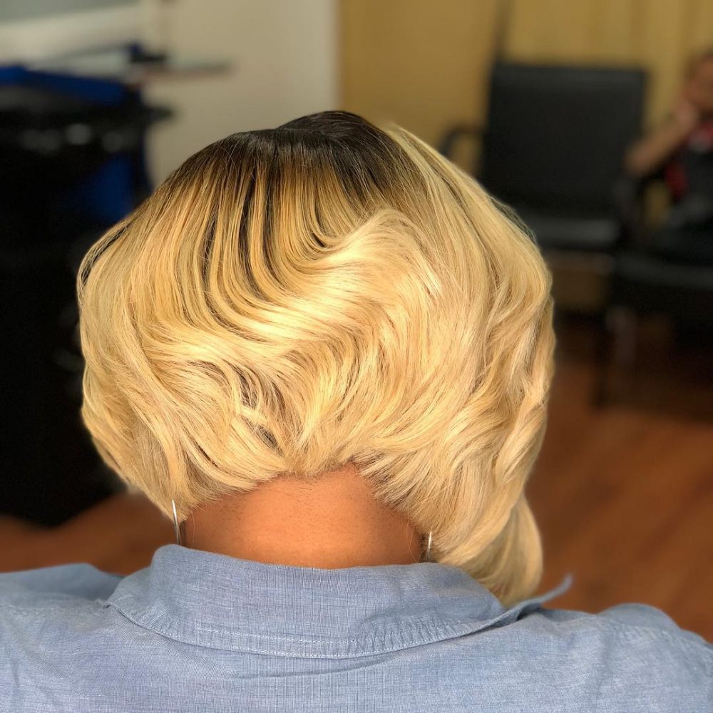 Layered blonde bob with movement and darker roots.