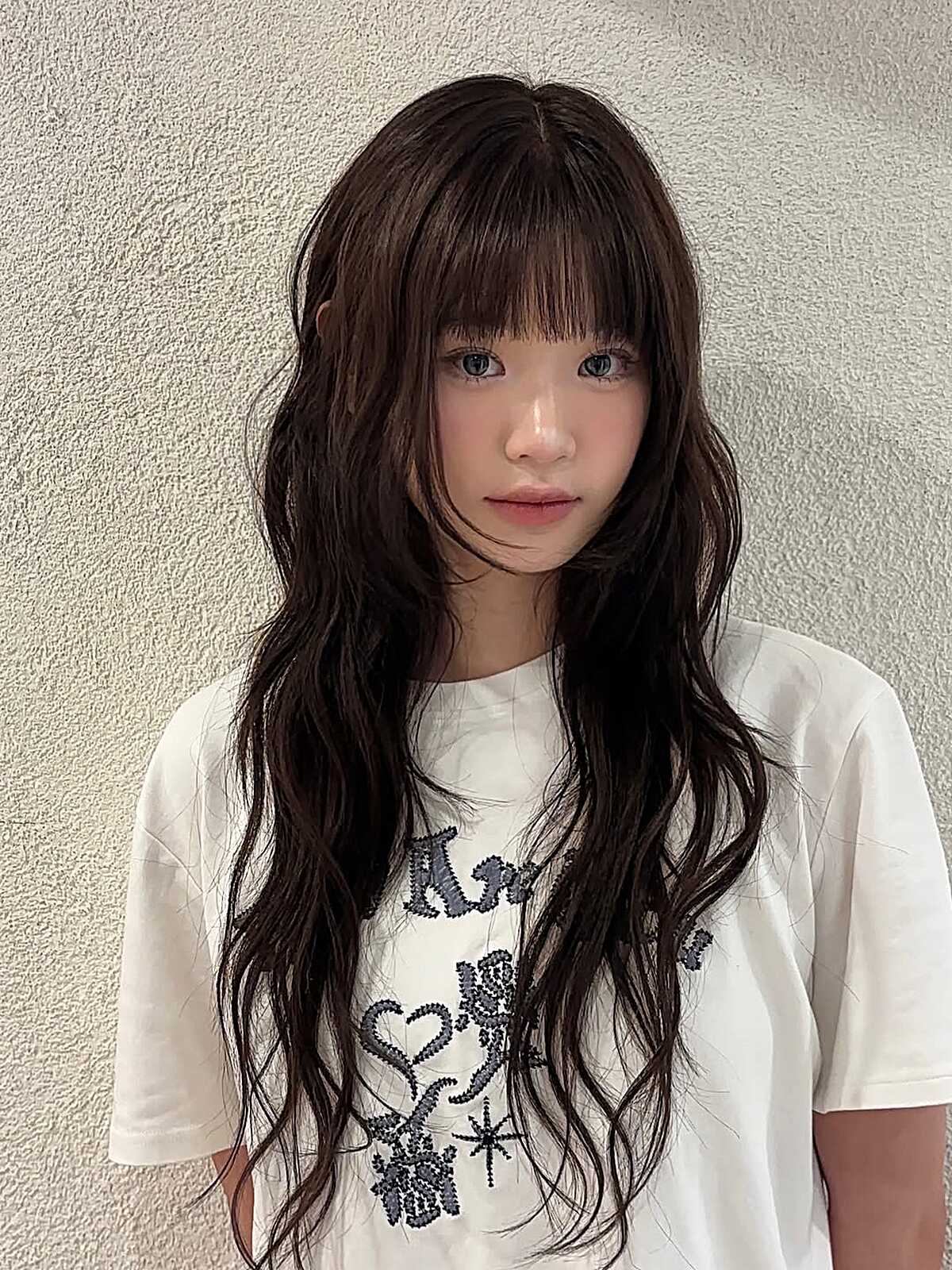 Long dark brown waves with delicate see-through bangs.