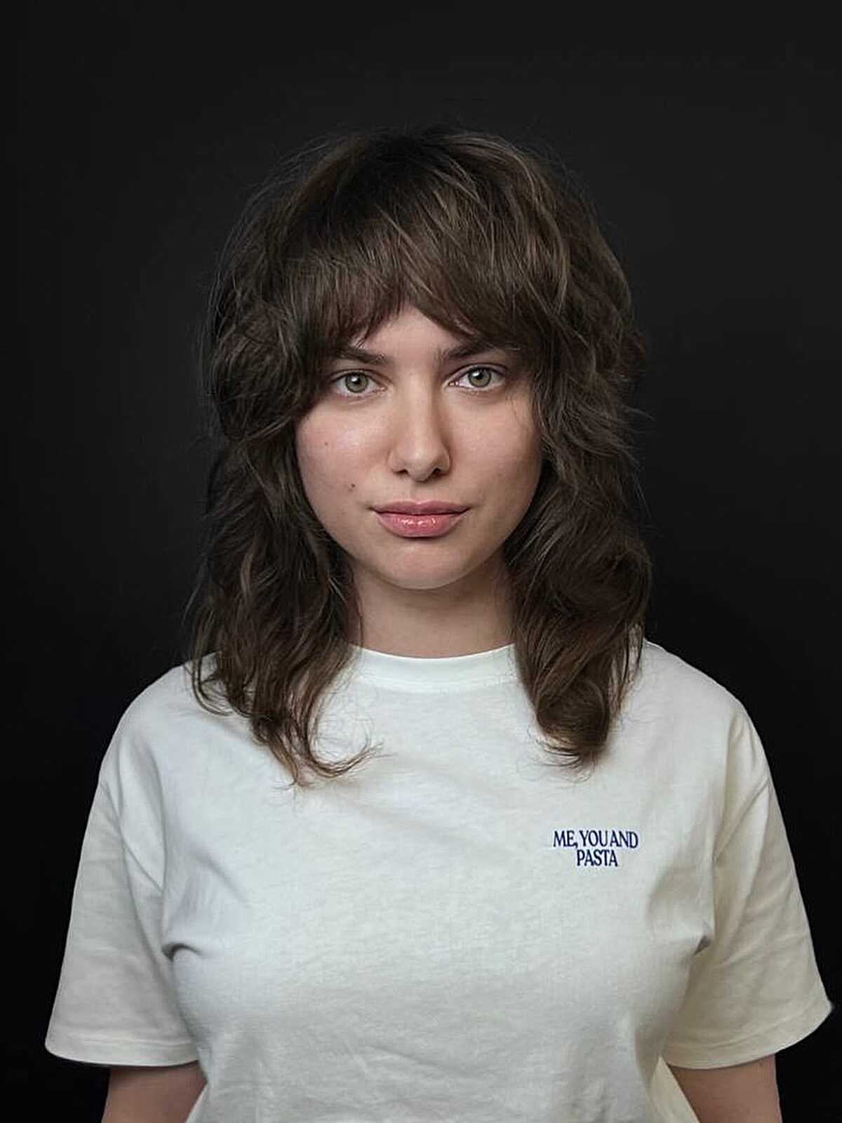 Dark wavy shag lob with full bangs and layered ends.