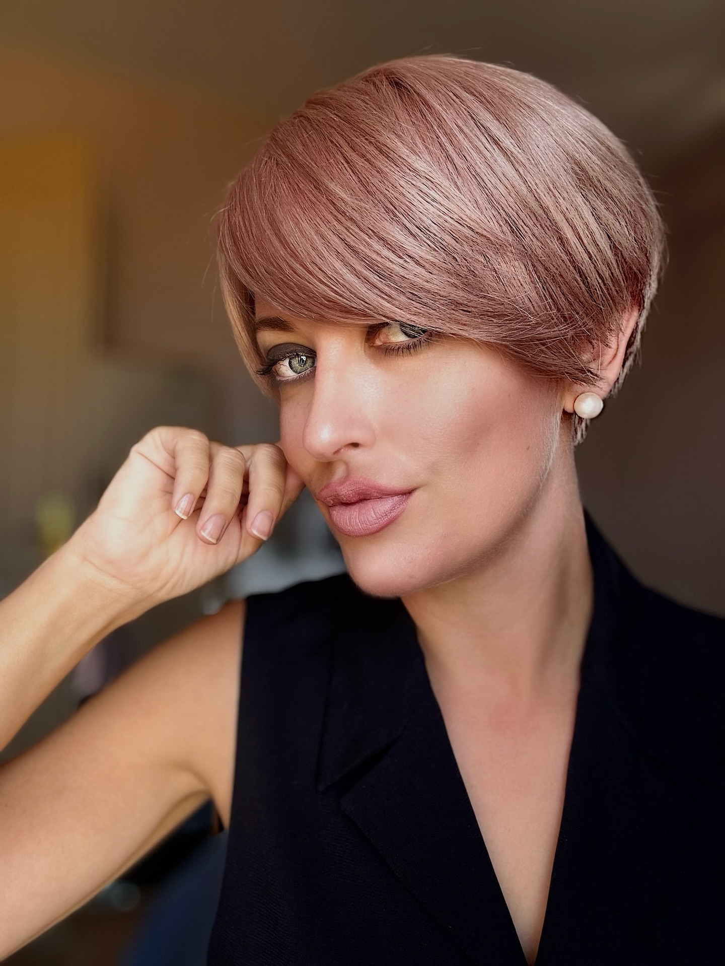 Rose beige pixie with rounded crown and side-swept fringe.