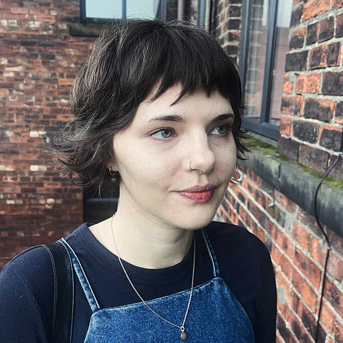 Dark wavy bob with grown-out bangs and soft, uneven ends